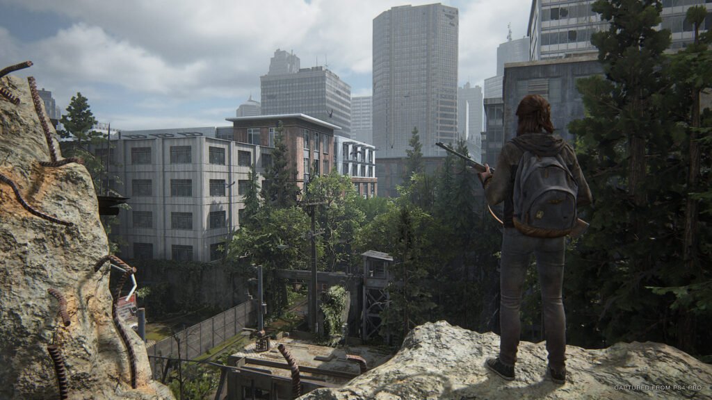 the last of us part ii Ellie observa Seattle do topo de uma montanha